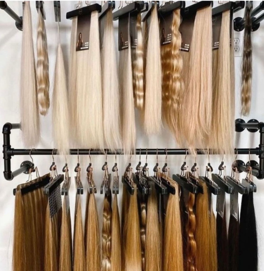 Extension color and texture display on salon wall racks from platinum blondes to deep brunettes